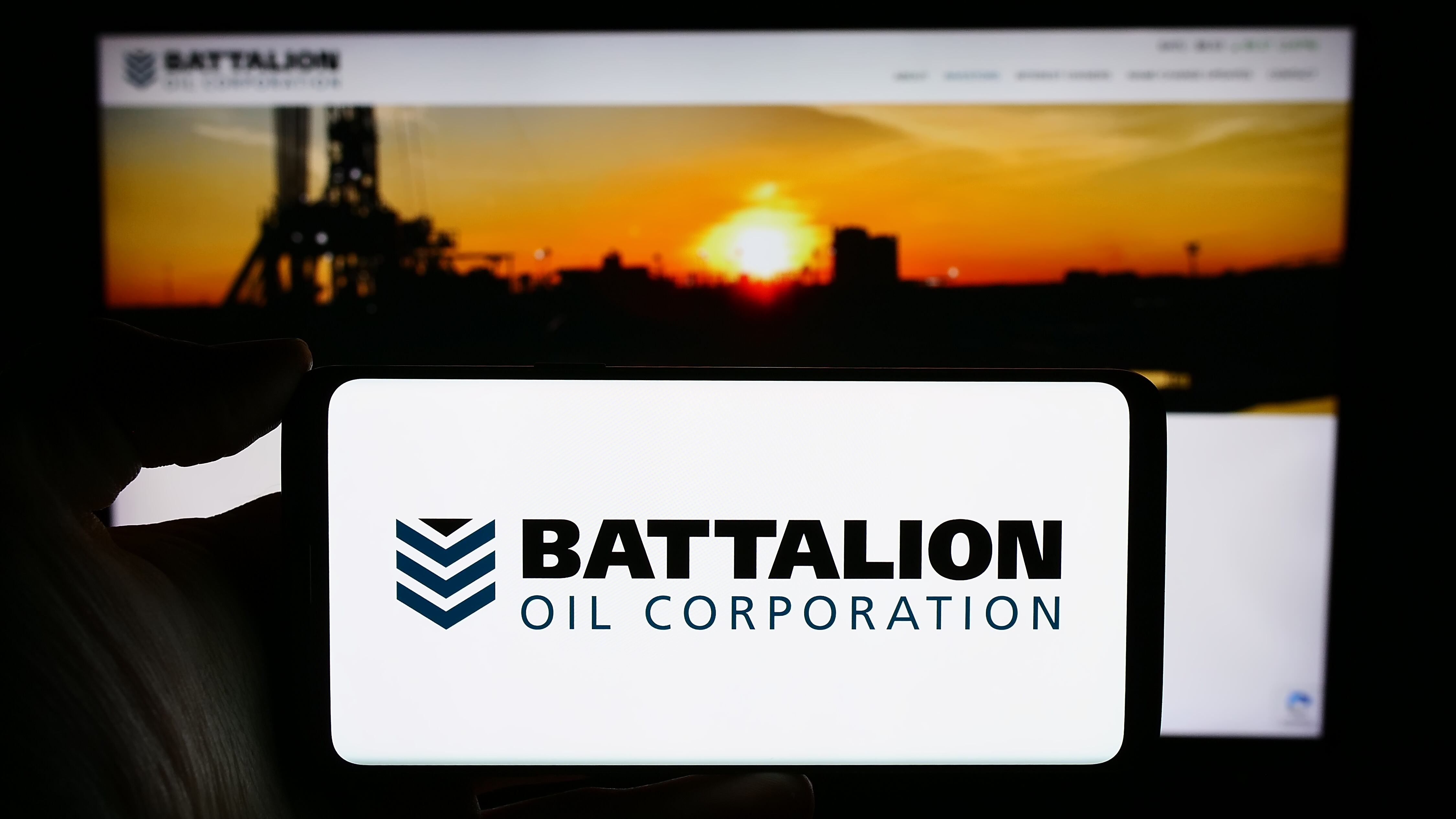 Battalion Oil Corp. logo shown on an iPhone with a white background, with the company's website shown in the background.