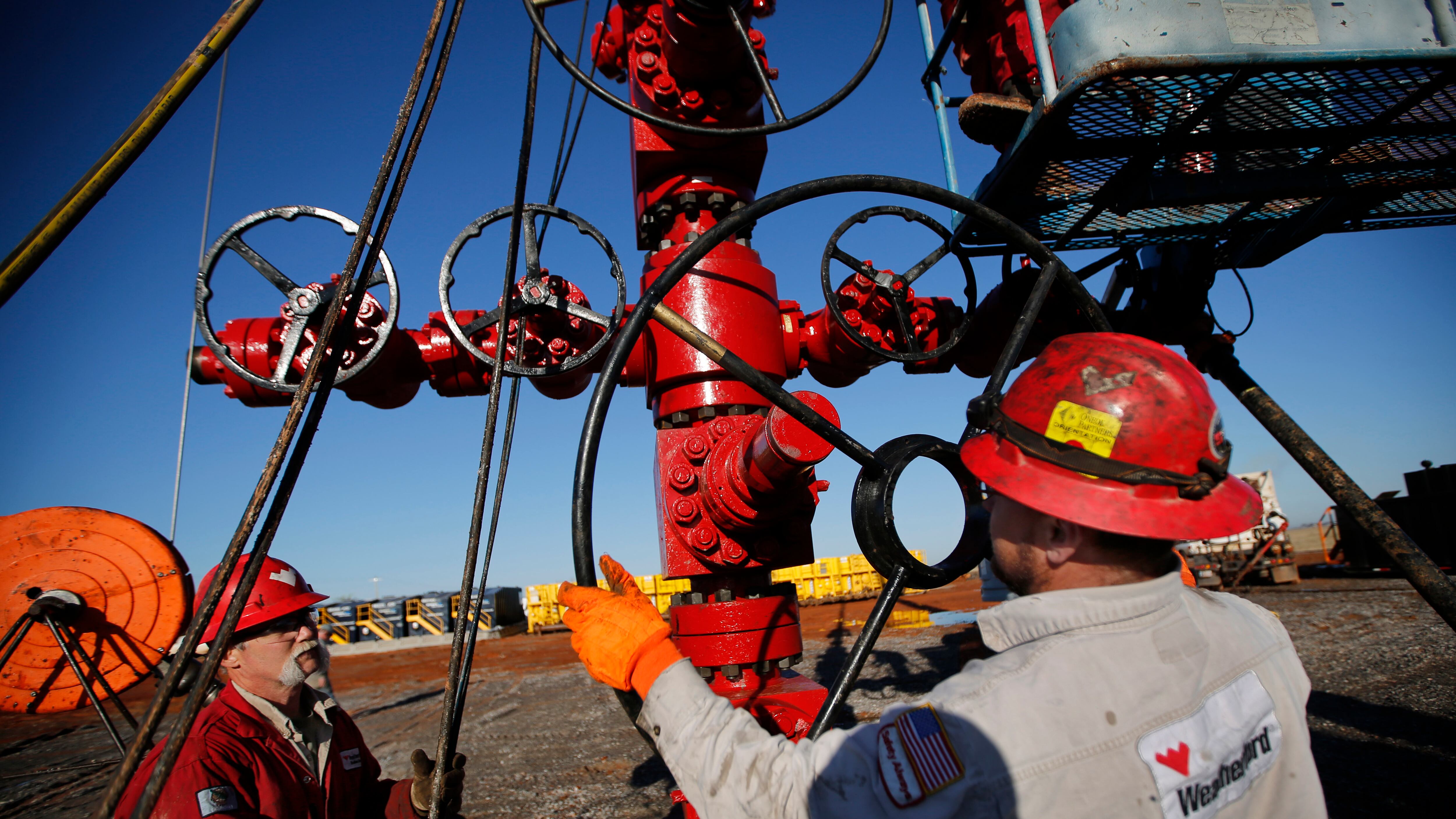 Weatherford operators Ken Hamilton (left) and crane operator Jeremy Weber turn the valves on the Holiday Road 2-1MH well head in Kingfisher County, Oklahoma, Monday, March 14, 2016. The wireline operation is being performed for Gastar Exploration.